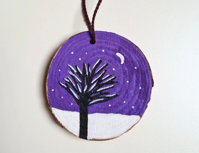 winter tree design created with acrylic marker pens on a hanging wood slice